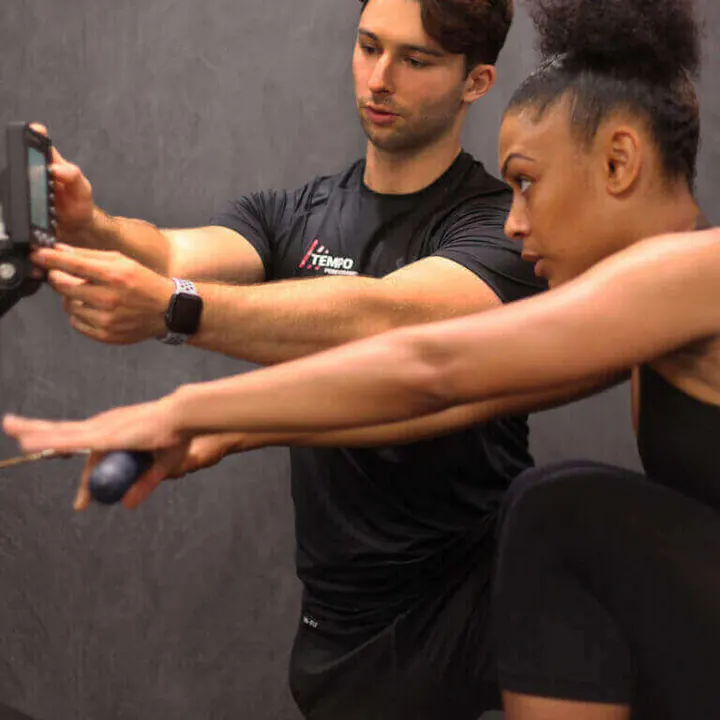 Julian Ernst coaching a client through a strength exercise