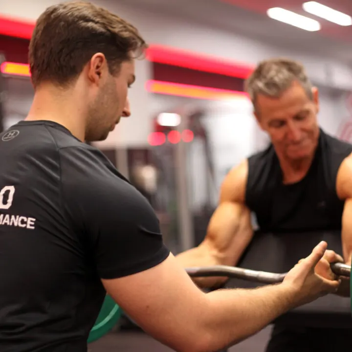Julian Ernst coaching a client during a strength exercise